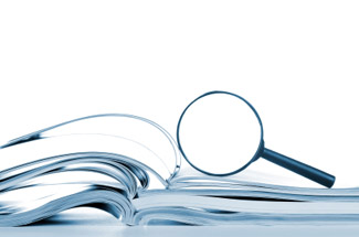 A magnifying glass placed on top of open books.